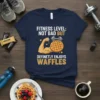 Funny t-shirt with "Fitness Level: Not Bad But Defineltly Enjoys Waffles" text, a flexing arm holding a dumbbell and waffle