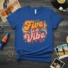 Retro "Five is a Vibe" graphic tee with wavy text in orange and pink, surrounded by stars and peace signs