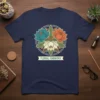 Navy t-shirt featuring a circular emblem of lotus flowers in teal, orange, and white, labeled "Floral Harmony"