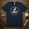 Navy t-shirt with white heron and gold floral border featuring text "Floral Lily of France"