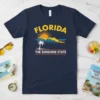 Florida The Sunshine State t-shirt design featuring state outline, palm tree, and sunset graphic