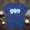 Blue t-shirt with the word "FLUFFY" in bold white letters on blue clouds, featuring cartoon kittens
