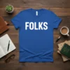 Bold white text spelling "FOLKS" on a royal blue t-shirt, minimalist design