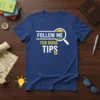 Follow Me For More Tips t-shirt design with magnifying glass and upward arrow graphic on navy blue tee