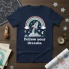 Follow your dreams quote with a rocket ship launching through a rainbow and stars on a navy t-shirt