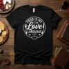 Black t-shirt with white text "Food Is My Love Language" inside a circle with cutlery and a bowl graphic