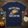 Navy t-shirt with white text reading "Food Stops Hunger Tacos Stop Pain" and a cartoon taco with rocket boosters