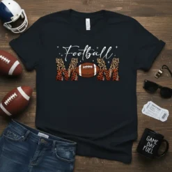 Black t-shirt with "Football MOM" design, featuring white script for "Football" and leopard print block letters with a football in