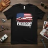 Foxbody text with a red classic Ford Mustang and American flag graphic on a black t-shirt
