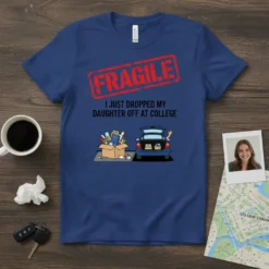 Blue t-shirt with "FRAGILE I JUST DROPPED MY DAUGHTER OFF AT COLLEGE" text and cartoon illustration of car trunk and