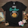 Black t-shirt with "FREE Brother HUGS" text and graphic of two arms hugging inside a sunburst circle