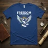 Freedom It's The Only Choice t-shirt featuring a white eagle with outstretched wings holding a flag, mountains, and sun rays