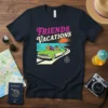 Friends Vacations text above a retro convertible driving on a winding road with a sunset graphic, on a navy t-shirt