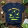 Frog Jumping Day May 13th t-shirt with cartoon frogs jumping on lily pads and yellow text