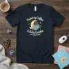 Fueled by Coffee & Baby Cuddles text with a cute moon, coffee cup, and pacifier graphic on a navy t-shirt