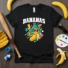 Black t-shirt with "BANANAS" text and a cartoon banana wearing sunglasses holding a baseball bat, set against a retro geometric