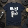 Navy blue t-shirt with white text "GAINS" and a graphic of a muscular arm flexing out of a cracked protein