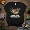 Sloth wearing headphones and holding a game controller, text "GAME OVER, I'M HIBHERATING" on a black t-shirt