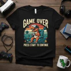 T-shirt with a cartoon T-Rex wearing VR goggles, playing video games, and the text "GAME OVER PRESS START TO CONTINUE"