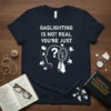 T-shirt with white text "GASLIGHTING IS NOT REAL YOU'RE JUST" above a graphic of a head in profile holding a