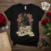 Black t-shirt with "Gatos Before Vatos" text, featuring a black cat sitting on sugar skulls surrounded by roses and hearts