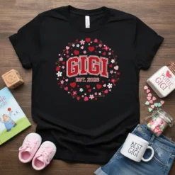 Black t-shirt with "Gigi Est. 2026" text surrounded by a floral and heart wreath