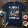 Glazed and Confused text with cartoon illustration of a person surrounded by pottery, on a navy blue t-shirt