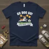 Navy blue t-shirt featuring a cartoon dog playing soccer with "GO DOG GO! SUPER BISCUIT LEAGUE" text. Includes biscuits and