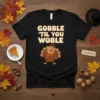 Black t-shirt with "Gobble 'Til You Woble" text and a cartoon turkey wearing a scarf and hat