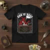 God Is Busy T-Shirt with a devil sitting at a desk, holding coffee and a book, with occult symbols