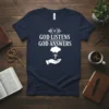 Navy blue t-shirt with white text "God Listens God Answers" and a graphic of a hand receiving blessings from a
