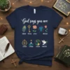 Navy t-shirt with "God says you are" in script, followed by icons and words: unique peacock feather, special key, lovely