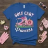 Blue t-shirt featuring "Golf Cart Princess" text with a pink golf cart and carriage graphic, and a castle silhouette