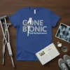 Blue t-shirt with "GONE BIONIC Total Hip Replacement" text and graphic of a hip joint implant