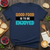 Good Food Is To Be Enjoyed text design with orange, white, and teal lettering on a navy t-shirt