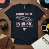 T-shirt with pink text "GOOD TASTE IN MUSIC BAD TASTE IN MEN" and a graphic of a guitar pick breaking