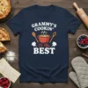 Grammy's Cookin' Is The Best text with a cooking pot graphic on a navy blue t-shirt