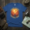 Grand Canyon National Park text with a desert landscape graphic featuring canyons, river, and sun on a blue t-shirt