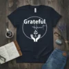 Grateful Heart t-shirt design with white typography and a seedling graphic held in hands within a circle