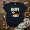 Black t-shirt with the word GRAVY in large white letters above a cartoon illustration of mashed potatoes, turkey legs, and