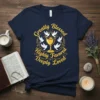 Navy t-shirt with yellow text "Greatly Blessed Highly Favored Deeply Loved" surrounded by doves and a chalice graphic