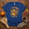 Greetings FALL ENJOY IT ALL text with scarecrow, turkey, pumpkin, and sunflower graphics on a blue t-shirt