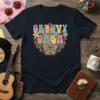 Groovy Gaga text in colorful retro font with flowers, peace signs, and a butterfly graphic on a navy t-shirt