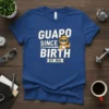 Guapo Since Birth Est. 2024 text with a cartoon lion wearing sunglasses and a crown on a blue t-shirt