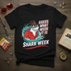 Guess What Week It Is Shark Week t-shirt with a cool shark in a hat and sunglasses emerging from water