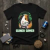 Guinea pig wearing headphones and holding a game controller, text reads "Guinea Gamer" on a black t-shirt