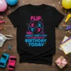Black t-shirt with bright pink and blue text and graphics: FLIP TUMBLE JUMP & PLAY I'M CELEBRATING MY BIRTHDAY TODAY