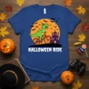 Halloween Ride T-Shirt featuring a green cartoon T-Rex riding a bicycle with bats and a haunted castle in the background
