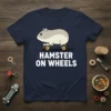 Hamster On Wheels text with a cute cartoon hamster riding a skateboard on a navy t-shirt