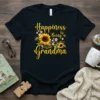 Happiness is Being a Grandma text with sunflower graphic on a black t-shirt, featuring yellow script font